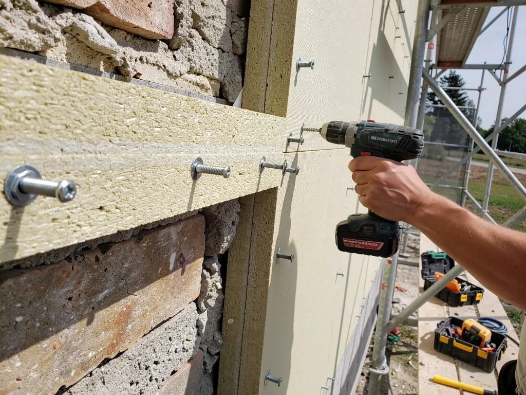 Panneaux isolants chevillés sur la façade pendant un chantier d'ITE
